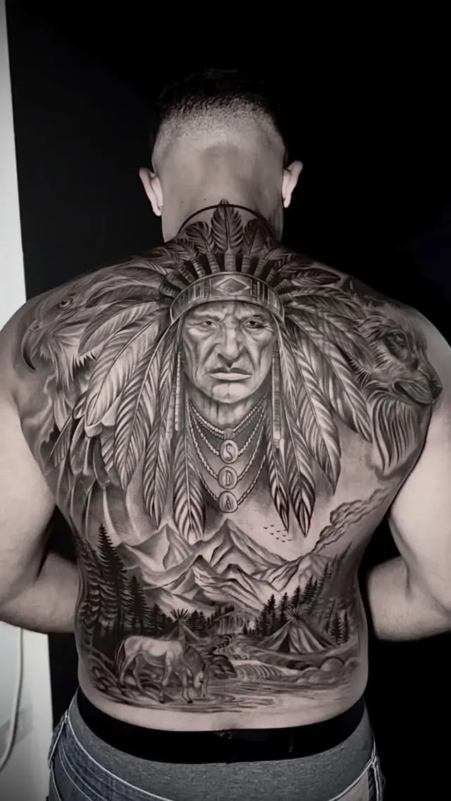 Full back piece of a chief in a feathered headdress above mountains