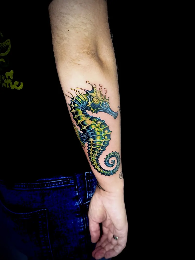 Green and yellow seahorse on a forearm